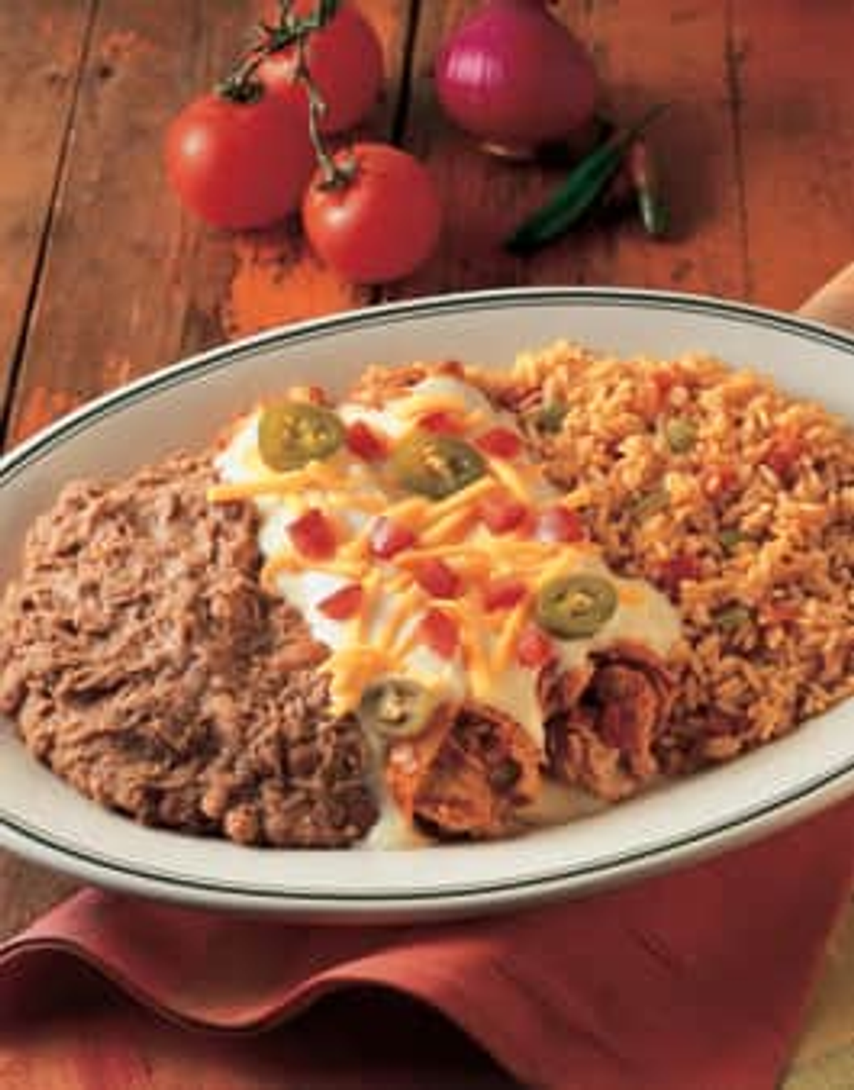 Mama's Favorite Enchilada Dinner with chili gravy, cheddar, rice and refried beans